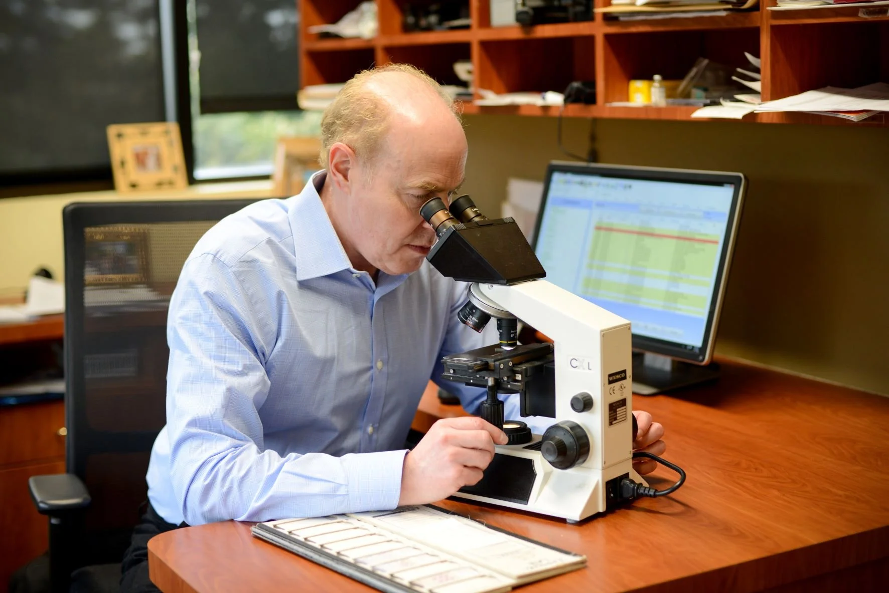Dr. Homa looking in microscope