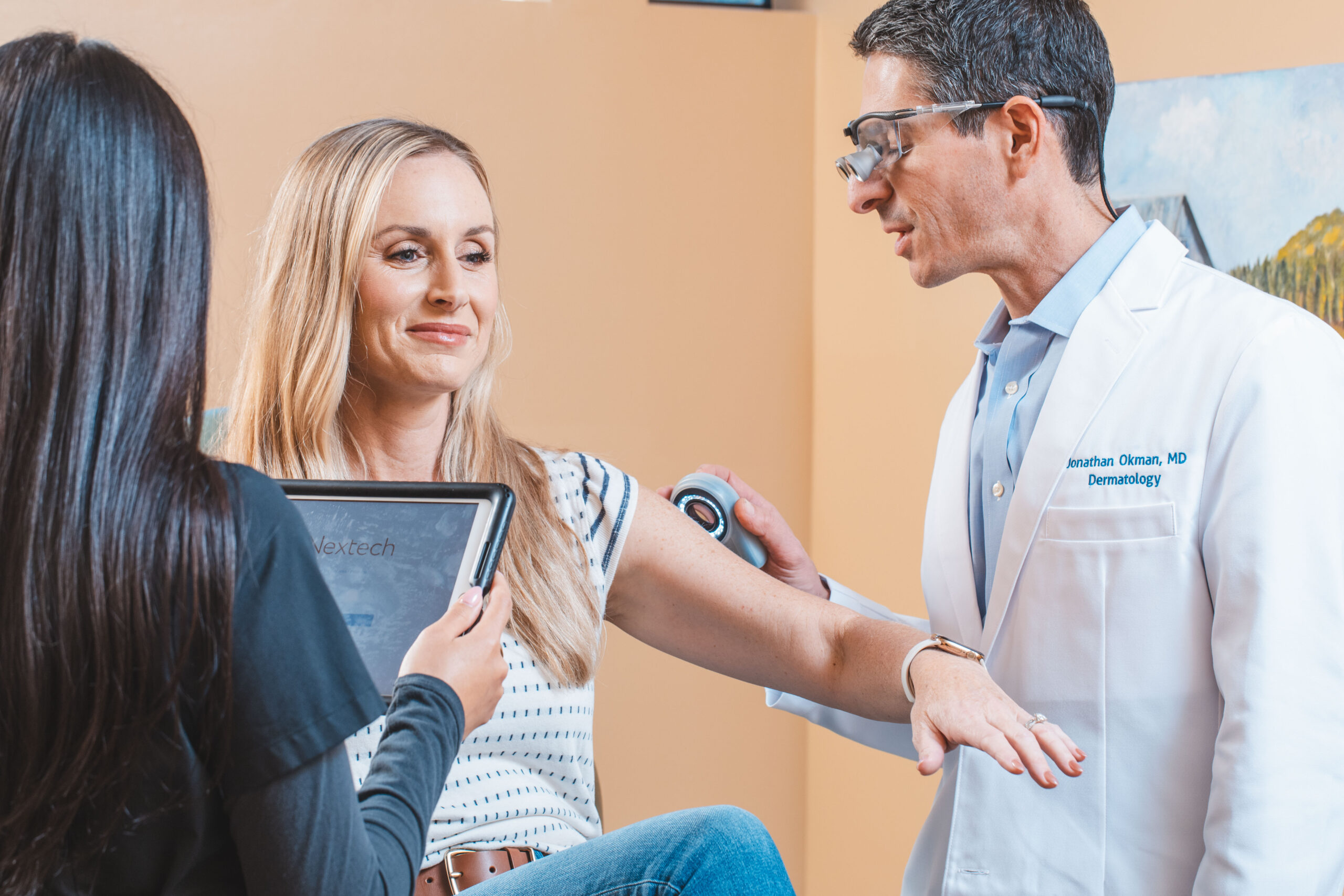 Dr. Okman assessing patient's skin