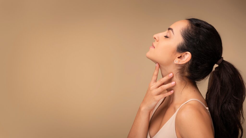 Woman touching neck and jawline after kybella treatment 