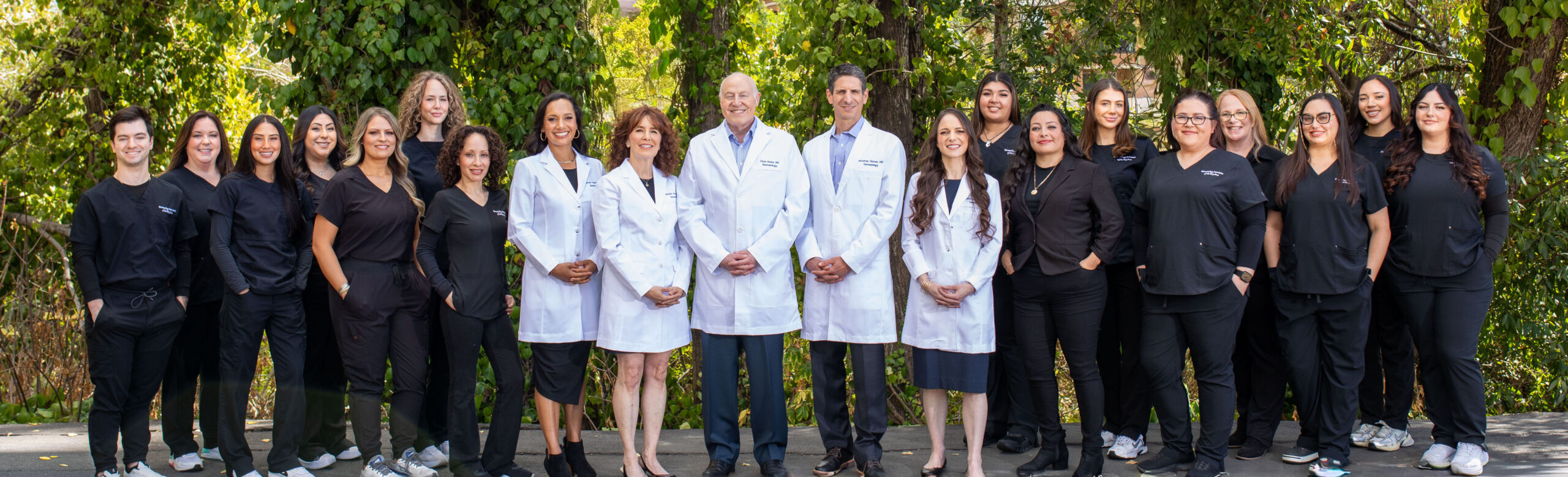 Dermatology Associates of the bay area doctors, pa, aesthetician, and staff. Group image outside.